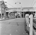 857312 Gezicht op het eerste perron en de voetbrug van het N.S.-station Woerden te Woerden.